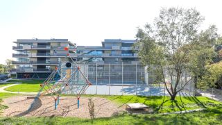 Modernes Schulgebude mit Terrassen und Spielplatz
